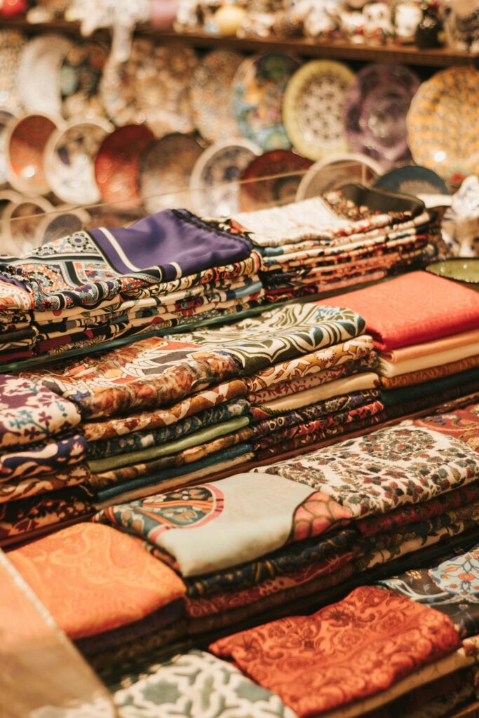 Colorful folded fabrics on display at Thankam Garments clothing sale, showcasing traditional and modern textile designs.